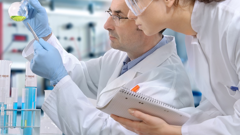 Two scientist looking at a beaker.