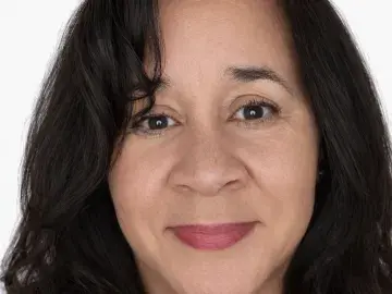 Smiling woman with dark hair in a headshot against a white background