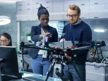 Makerspace: Innovative entrepreneurs working with a robotic arm