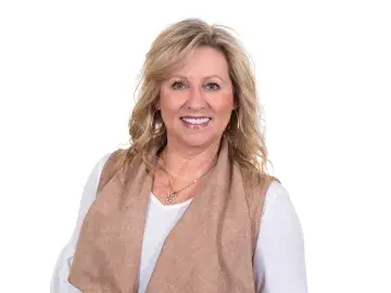 Diana Smith in white top and tan vest against a white background.