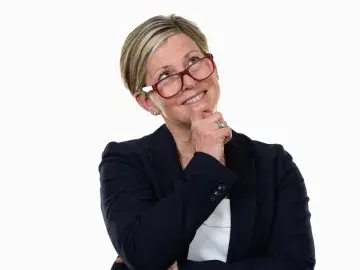 Elizabeth Good Mazhari in a dark blazer, hand on chin, on white background.