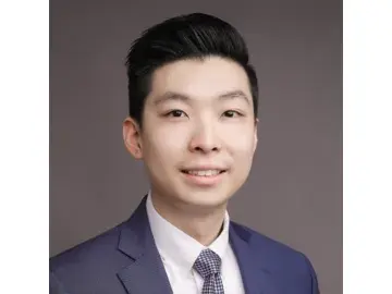 Chung Hei Sing in a suit and tie against a gray background