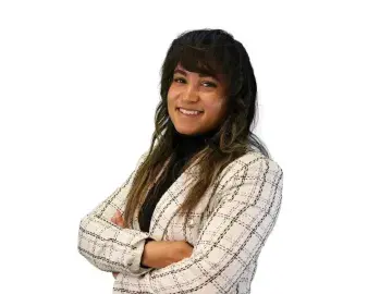 Brittney Jackson with long dark hair, arms crossed, on a white background.