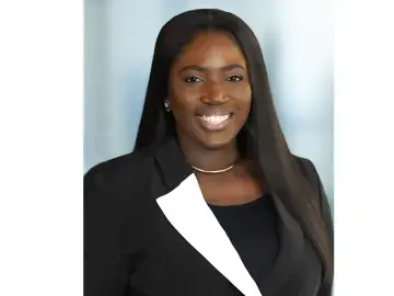 Fey Okupe in a black blazer on gray background.