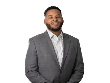Justin Ferguson smiling in gray suit standing against a white background.