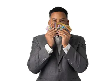 Justin Ferguson holding a fan of cards covering his face on a white background.