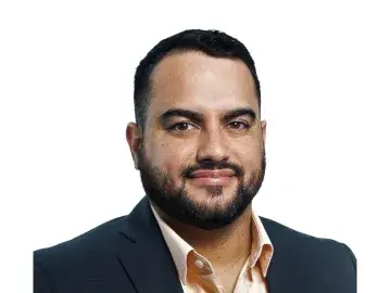 Ricardo Alvarado in a dark blazer on a white background