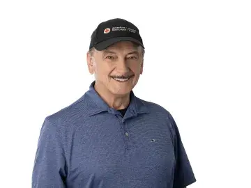 Ron Kaese in a black cap and blue polo shirt on a white background