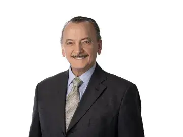 Ron Kaese in a dark suit and tie against a white background.