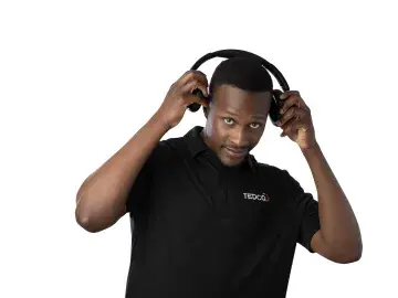Claudius Taylor in black polo adjusting headphones against a white background