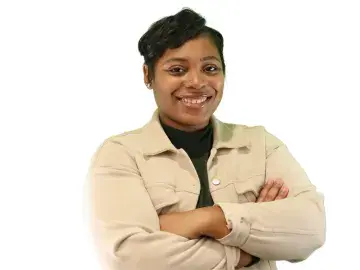 DeJonna Farrar with arms crossed in beige jacket against white background.