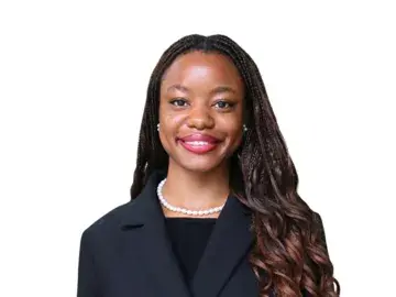 Ebahi Adubor navy blazer and pearl necklace on white background.