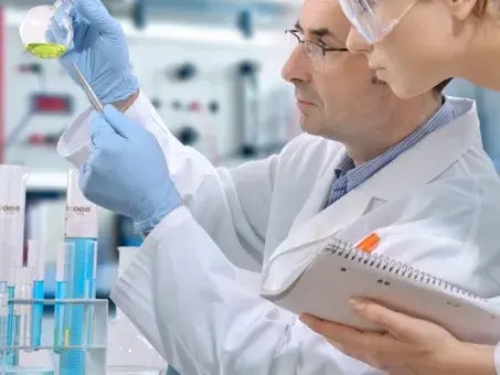 Two scientist looking at a beaker. 