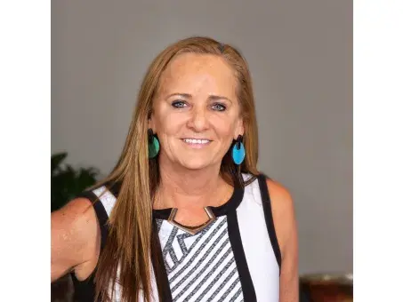 Kathie Callahan Brady in striped sleeveless top against a gray background
