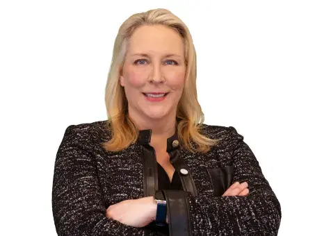 Katherine Hill Ritchie with arms crossed, wearing a dark blazer on a white background.