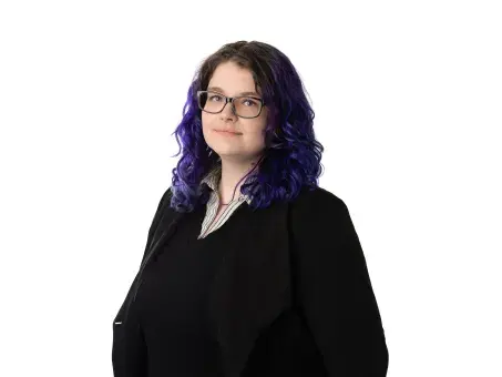Rachael Kalinyak with glasses and wavy dark hair with purple ends