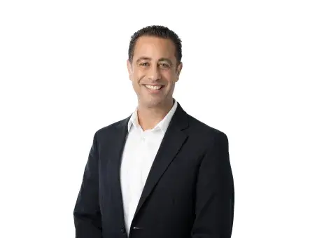Ben Antebi in dark suit jacket and white shirt against a white background