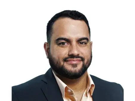 Ricardo Alvarado in a dark blazer on a white background