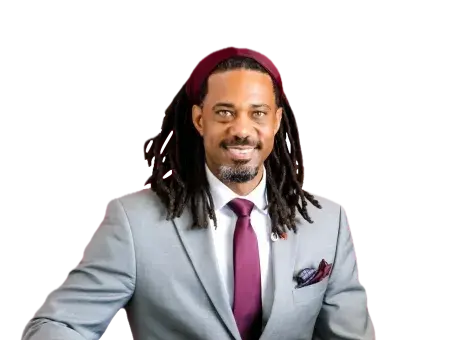 Kory Bailey in a light gray suit and burgundy tie, seated on a black background