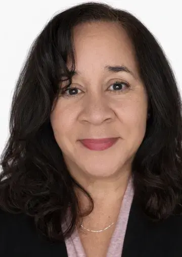 Smiling woman with dark hair in a headshot against a white background